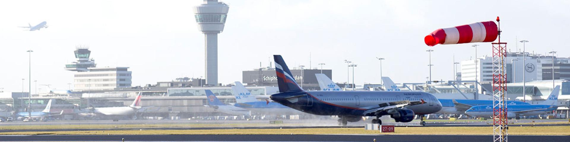 Beeld van luchthaven Schiphol met de verkeerstoren op de achtergrond